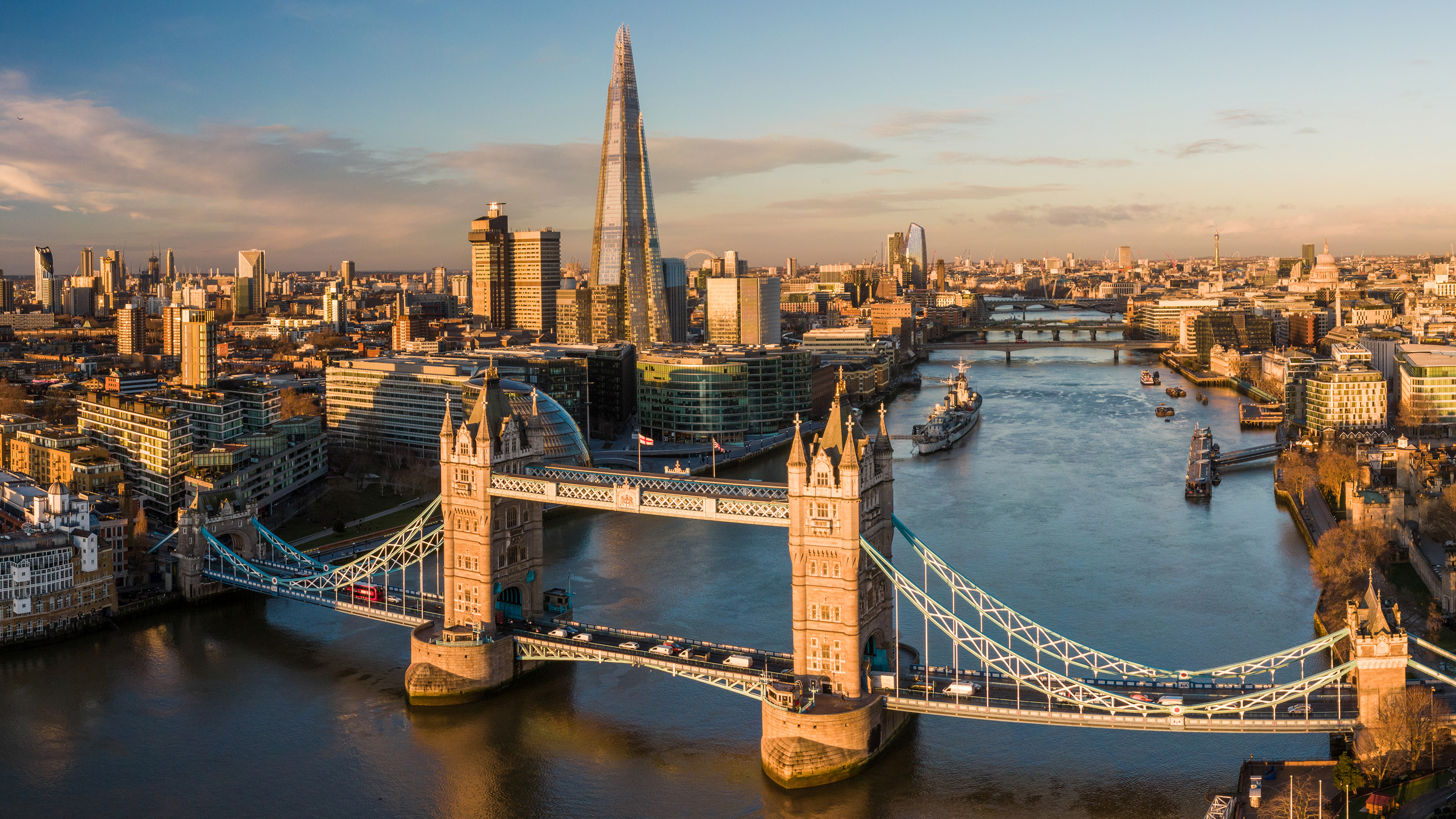 Aerial view looking over London and the River Thames, with Tower Bridge in the foreground.