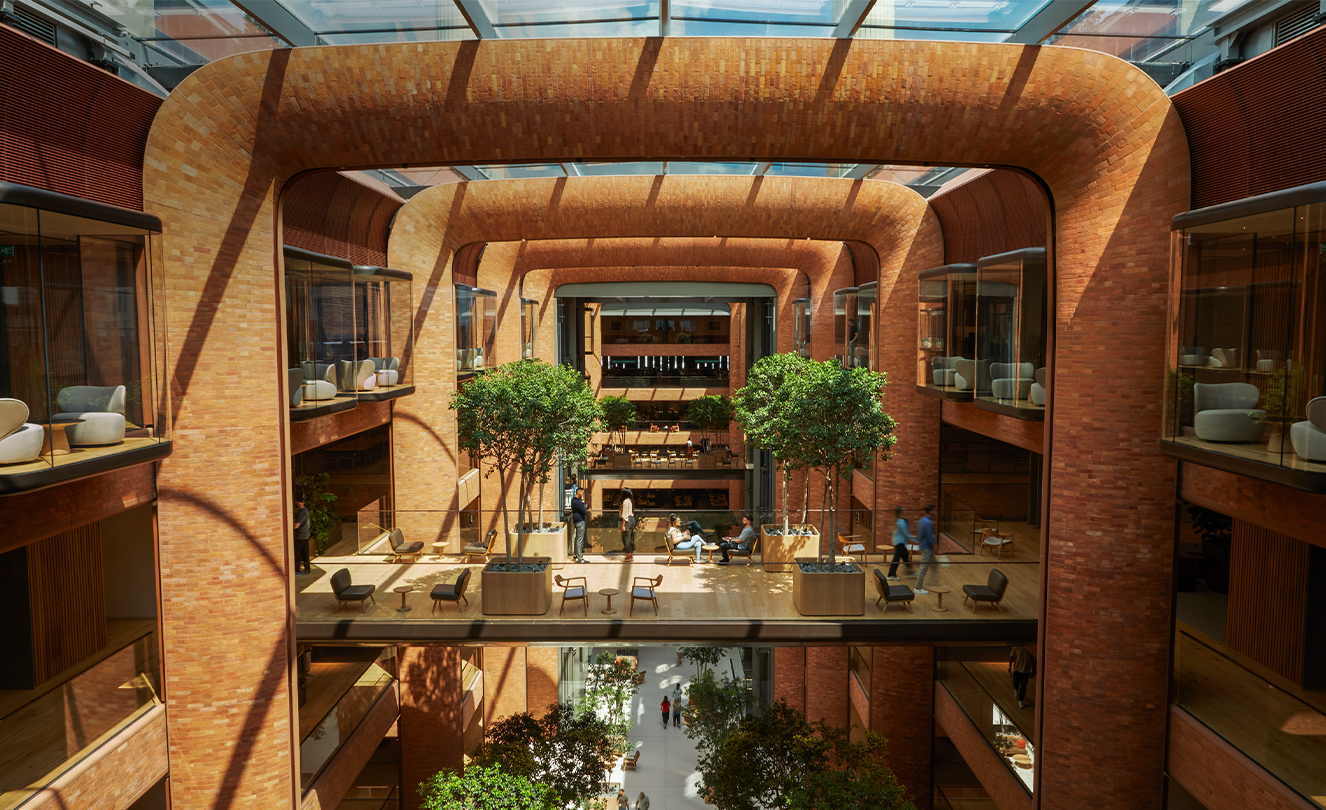 The five-story Battersea atrium with the sun streaming in through the glass roof, lighting team members below.