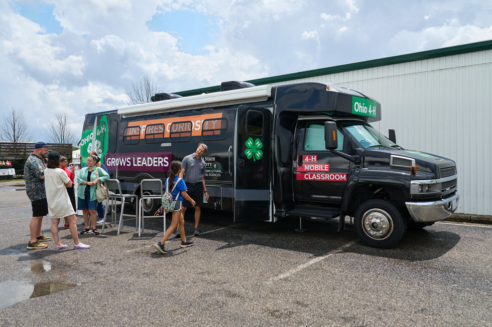 Un grupo de jóvenes fuera del salón de clases ambulante de 4-H en un autobús.