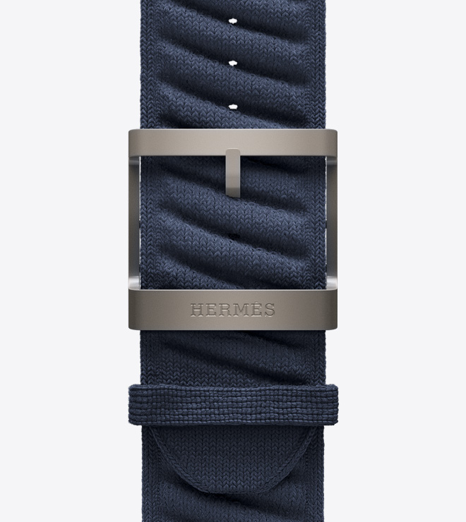 Close-up view of the new textured knit En Mer strap in Bleu Nuit (blue) with a titanium buckle.